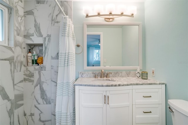 bathroom featuring toilet, walk in shower, and vanity