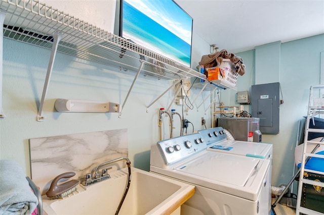 clothes washing area featuring sink, washer and clothes dryer, electric panel, and water heater