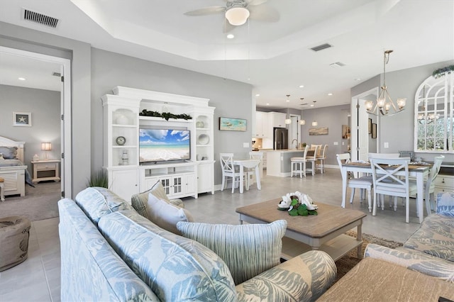 12488 Palatka Dr, Venice, FL 34293 - living room featuring a raised ceiling and ceiling fan with notable chandelier