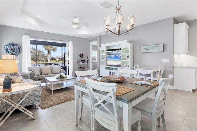 12488 Palatka Dr, Venice, FL 34293 - tiled dining space featuring ceiling fan with notable chandelier and a tray ceiling