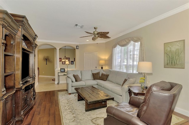 living room featuring ceiling fan, ornamental molding, ornate columns, and wood-type flooring