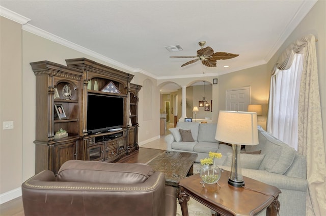 living room featuring ceiling fan, hardwood / wood-style flooring, ornamental molding, and ornate columns