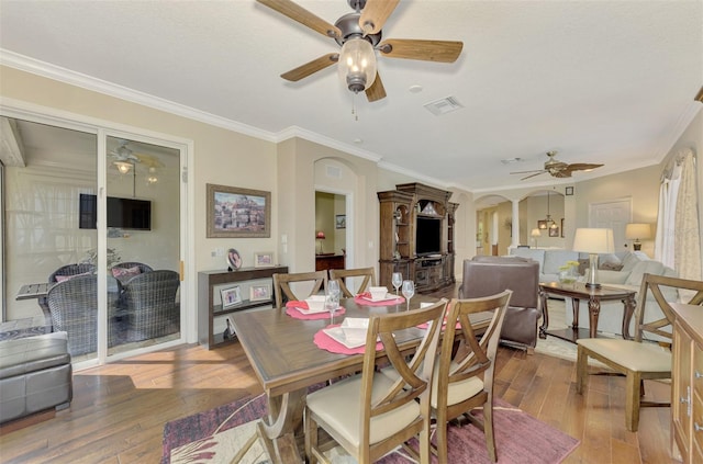 dining room with hardwood / wood-style flooring and crown molding