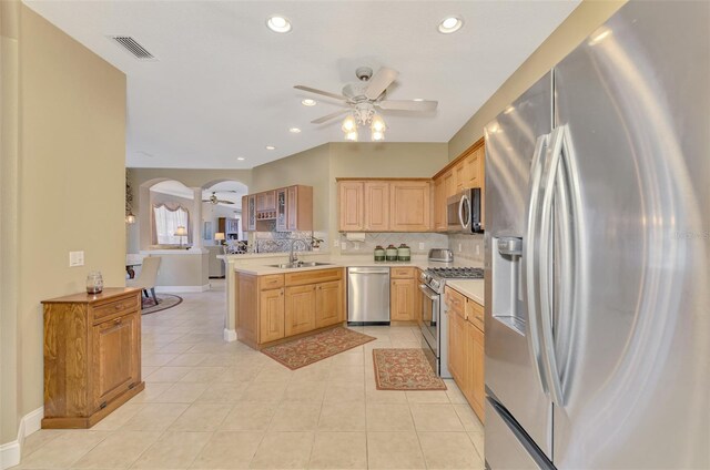 kitchen with ceiling fan, appliances with stainless steel finishes, kitchen peninsula, and sink