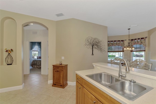 kitchen with light tile patterned flooring, a chandelier, pendant lighting, and sink