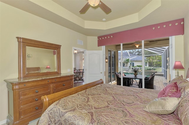 bedroom with access to outside, ceiling fan, and a raised ceiling