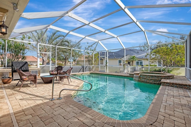 view of swimming pool with glass enclosure, a patio area, and an in ground hot tub