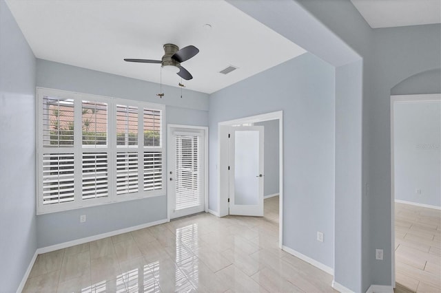 spare room featuring ceiling fan and light tile patterned floors