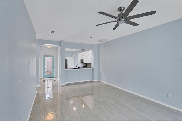 unfurnished living room featuring ceiling fan