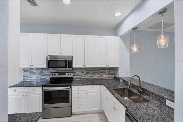 kitchen featuring white cabinetry, stainless steel appliances, tasteful backsplash, sink, and hanging light fixtures