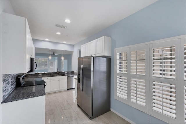 kitchen featuring pendant lighting, backsplash, white cabinetry, and stainless steel appliances