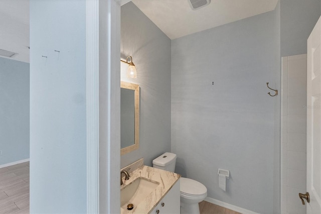 bathroom featuring vanity, toilet, and hardwood / wood-style floors