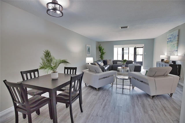 living room featuring a textured ceiling and light hardwood / wood-style flooring