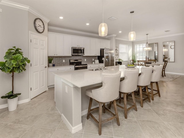 kitchen with sink, white cabinetry, hanging light fixtures, a center island with sink, and appliances with stainless steel finishes