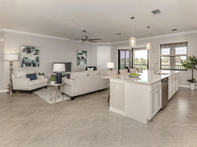 kitchen featuring sink, dishwasher, an island with sink, white cabinets, and decorative light fixtures