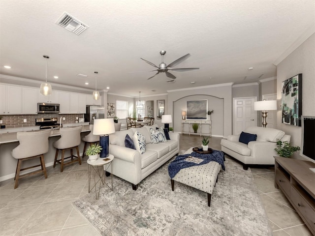 living room featuring light tile patterned floors, ornamental molding, and sink