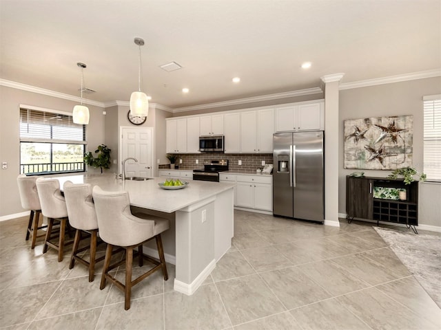 kitchen with stainless steel appliances, sink, a center island with sink, and white cabinets