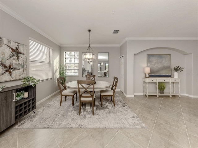 dining space featuring light tile patterned flooring, a notable chandelier, and crown molding