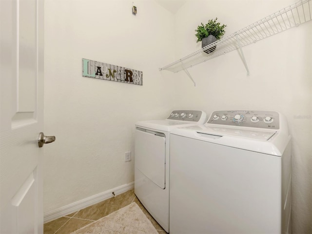 laundry room featuring washing machine and dryer and light tile patterned flooring