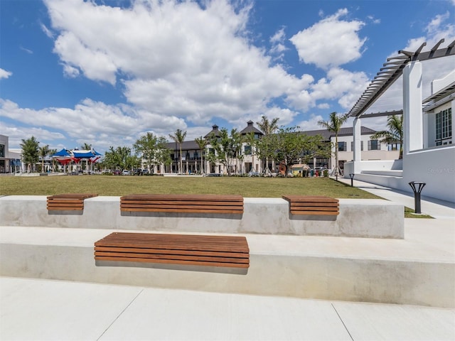 surrounding community featuring a yard and a pergola