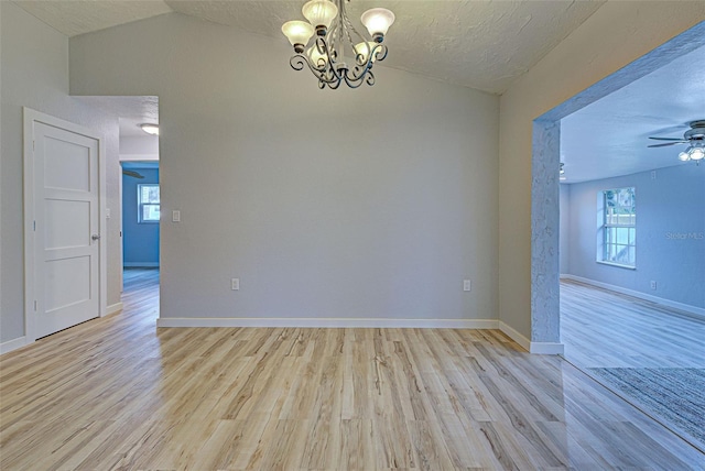 unfurnished room with ceiling fan with notable chandelier, vaulted ceiling, a textured ceiling, and light hardwood / wood-style flooring