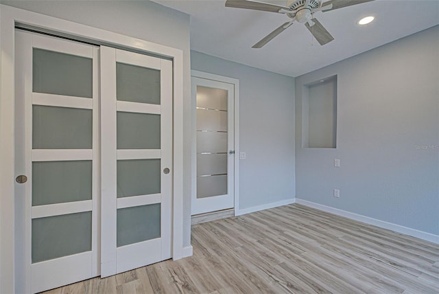 empty room with ceiling fan and light hardwood / wood-style flooring