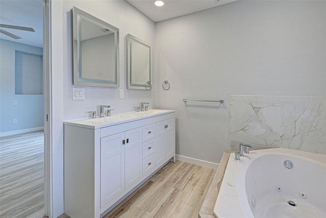 bathroom featuring vanity, a tub to relax in, wood-type flooring, and ceiling fan