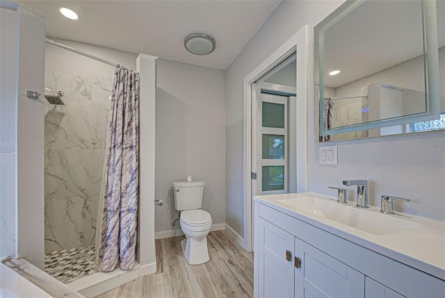 bathroom featuring toilet, hardwood / wood-style floors, vanity, and walk in shower