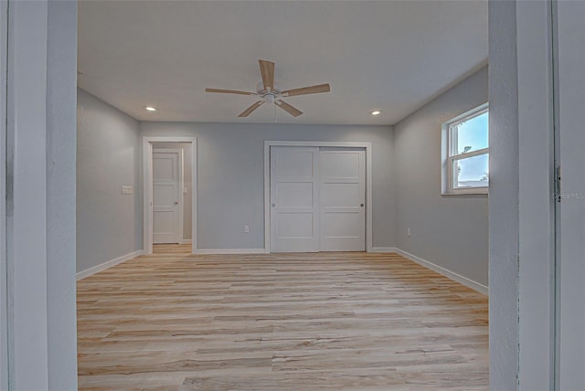 unfurnished bedroom with light wood-type flooring, ceiling fan, and a closet