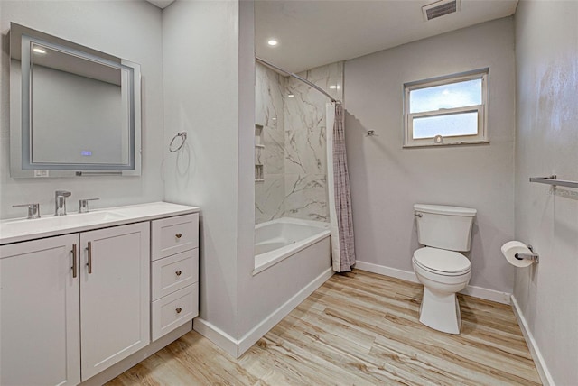 full bathroom featuring wood-type flooring, vanity, shower / tub combo, and toilet