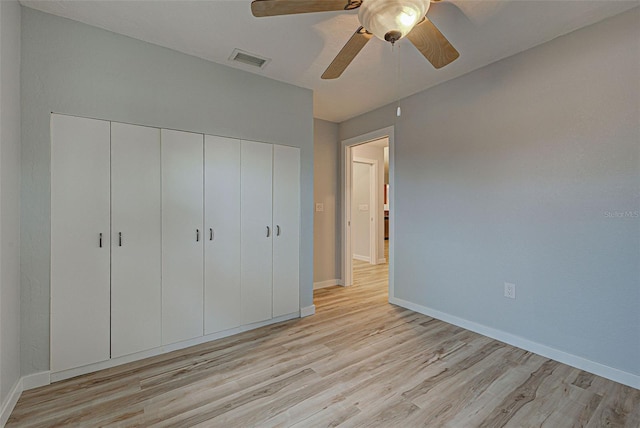 unfurnished bedroom featuring light hardwood / wood-style flooring, ceiling fan, and a closet