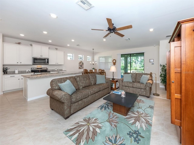 tiled living room featuring ceiling fan and sink