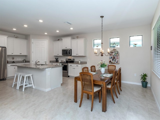 dining room featuring sink, light tile patterned floors, and a notable chandelier