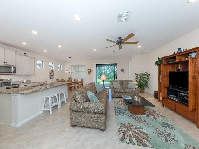 living room featuring ceiling fan, light tile patterned flooring, and sink