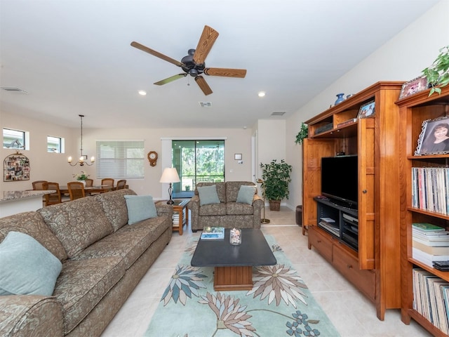 tiled living room featuring ceiling fan with notable chandelier