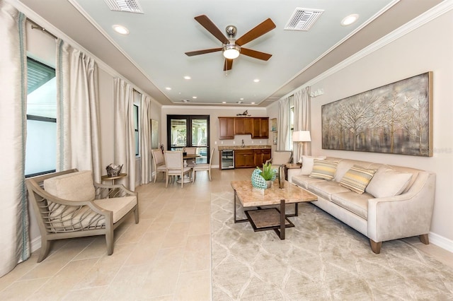 living room featuring ceiling fan, beverage cooler, and sink