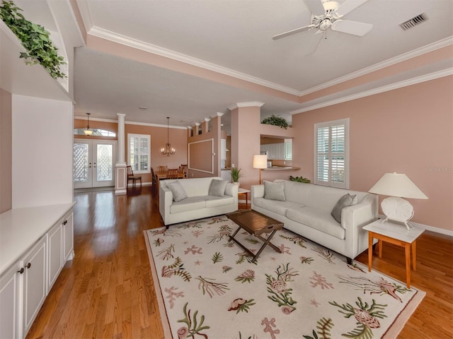 living room featuring french doors, plenty of natural light, ceiling fan with notable chandelier, and light hardwood / wood-style flooring