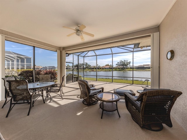 sunroom / solarium with a wealth of natural light, ceiling fan, and a water view