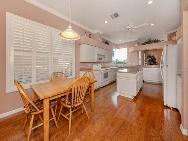 kitchen with pendant lighting, white cabinetry, ornamental molding, light hardwood / wood-style floors, and white appliances