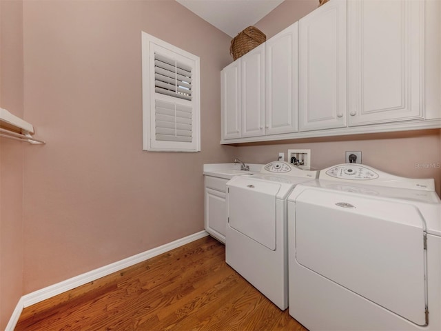 washroom with cabinets, separate washer and dryer, sink, and light hardwood / wood-style flooring