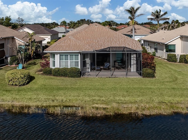 rear view of property with a lanai, a lawn, and a water view