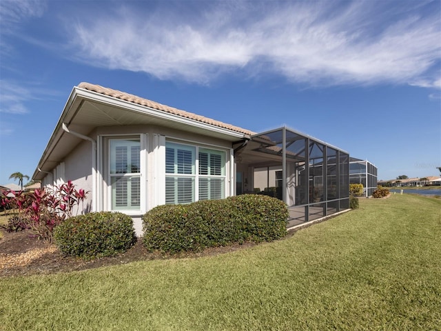 exterior space featuring a lanai and a lawn