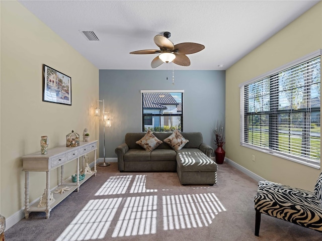 living room featuring a textured ceiling, ceiling fan, and carpet