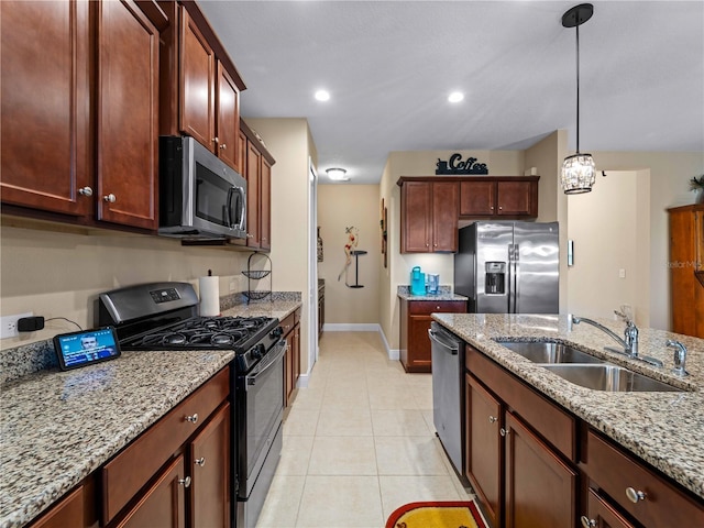 kitchen featuring sink, hanging light fixtures, light tile patterned floors, stainless steel appliances, and light stone countertops