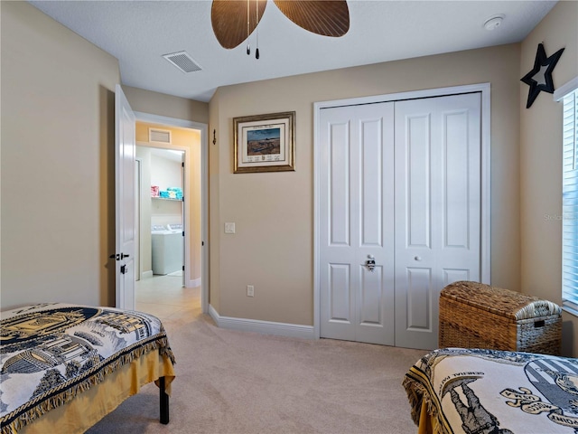 carpeted bedroom featuring washer / clothes dryer, ceiling fan, and a closet