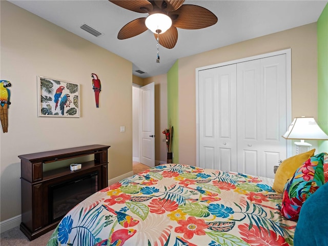 carpeted bedroom with ceiling fan and a closet