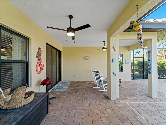 view of patio / terrace with ceiling fan and glass enclosure