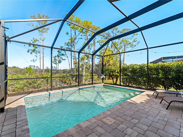 view of swimming pool featuring a patio area and glass enclosure