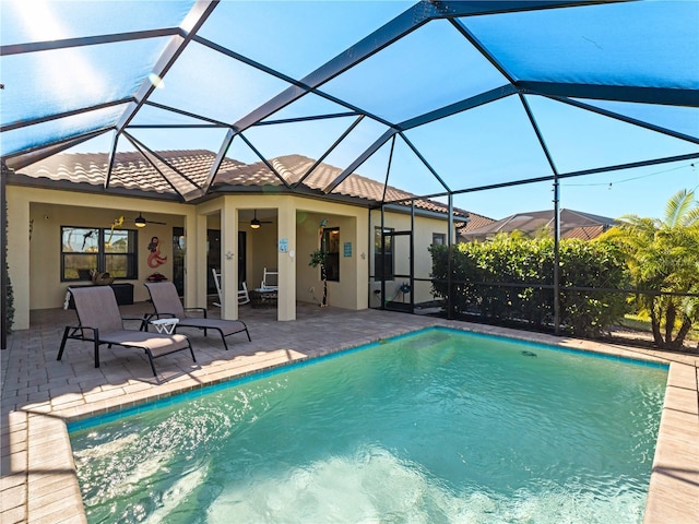 view of pool with a patio, ceiling fan, and glass enclosure