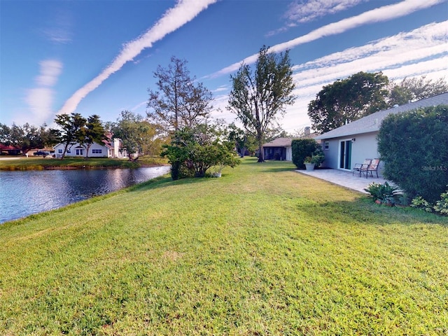 view of yard with a water view and a patio area